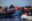 crew member from the Humanity 1 passing on life vests from a rescue boat to a boat with refugees.